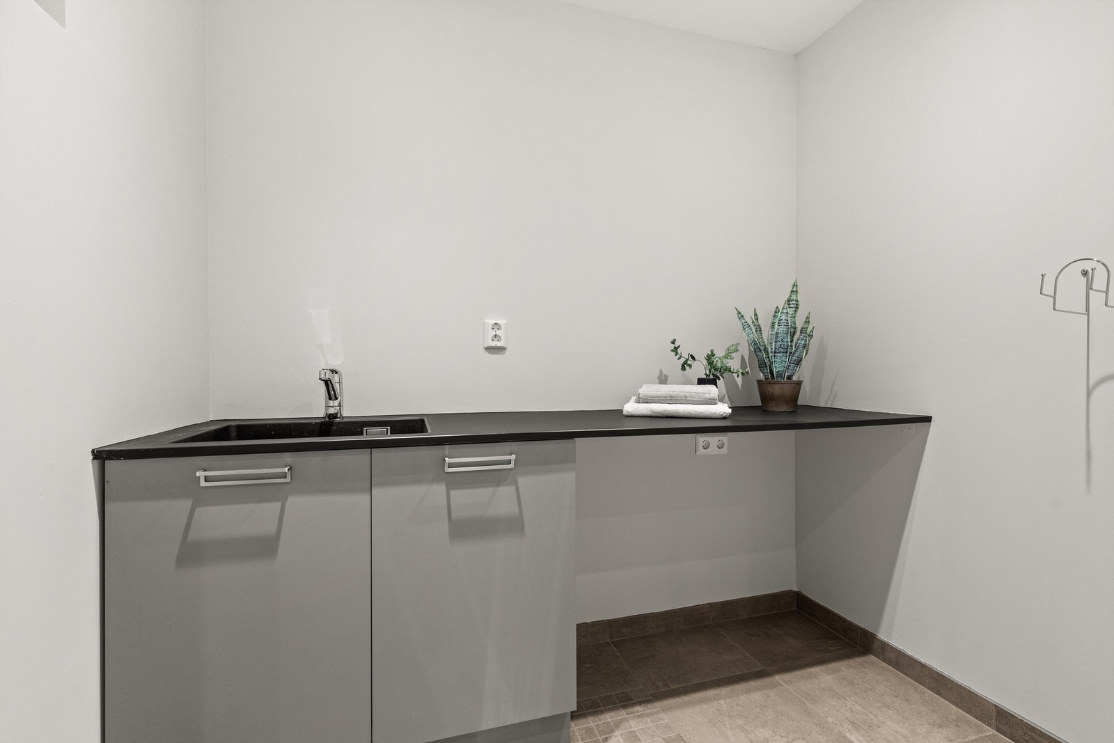 Praktisk vaskerom med skapinnredning og varmekabler Galleribilde