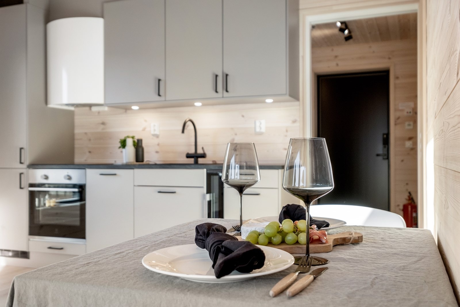 Kjøkkenet har et moderne utseende med slette fronter, integrerte hvitevarer og vinskap. Galleribilde