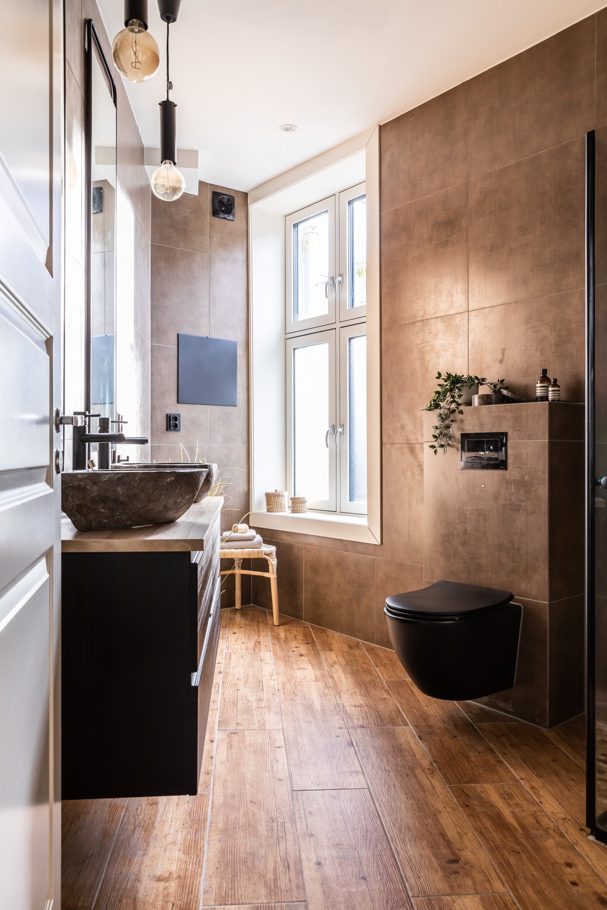 Badet har stilige trelignende gulv, dobbel vask, vegghengt toalett og dusjhjørne Galleribilde