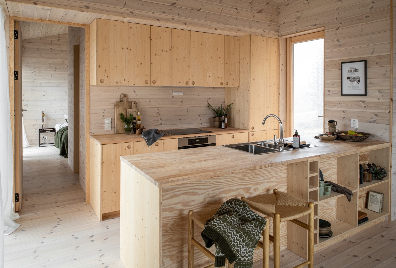 Kjøkkenet har snekkertilpasset innredning i finér og heltre benkeplate. Galleribilde