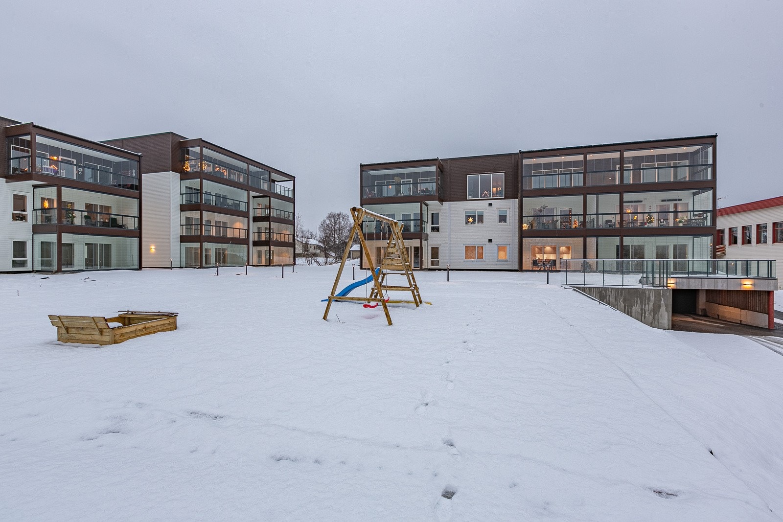 Opparbeidet uteområde, her med lekeplass og innkjørsel til parkeringskjeller. Galleribilde