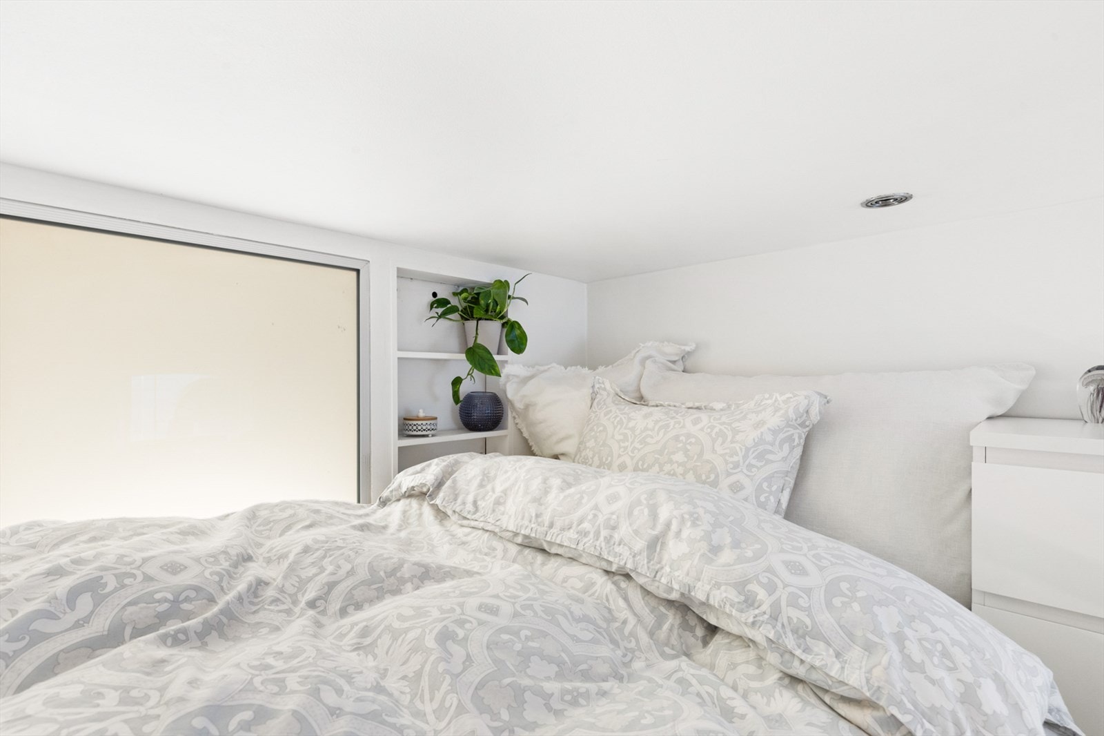 På hemsen har man hyllesystem og nattbord ved siden av sengen. Galleribilde