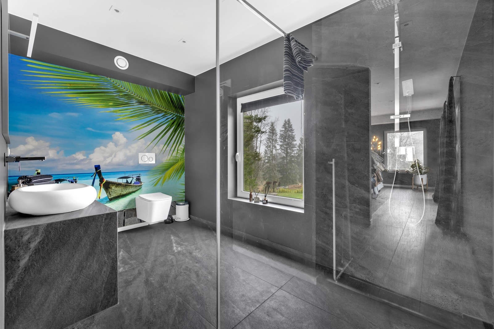 Badet ved hovedsoverommet er helfliset og lekkert, og har regnfallsdusj bak en storglassvegg. Galleribilde