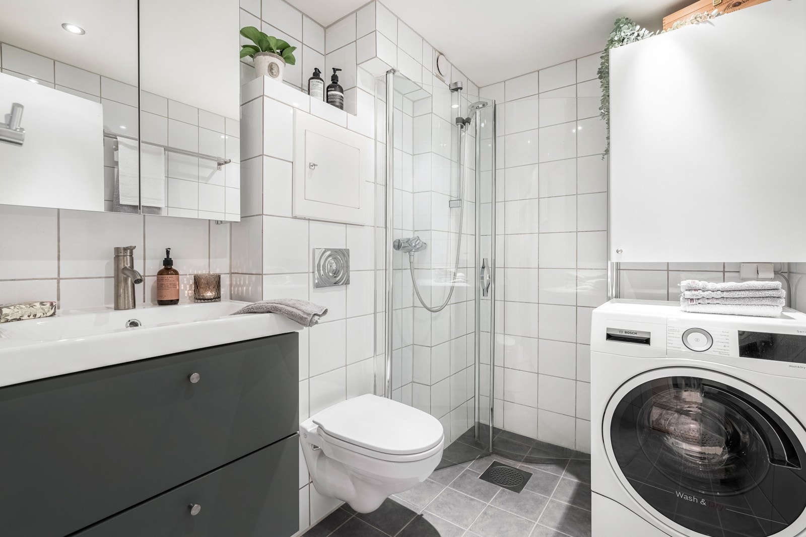 Badet er utstyrt med baderomsinnredning med servant og ett-greps blandebatteri, speil, lys, dusjhjørne med glassdører og vegghengt toalett. På badet er det opplegg for vaskemaskin. Denne medfølger. Det ble montert ny servant og speilskap i 2021. Galleribilde