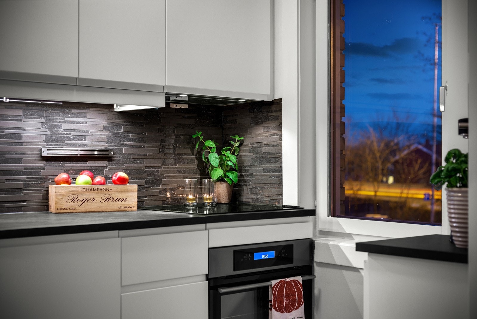 Integrerte hvitevarer som komfyr, induksjon platetopp (2022) og oppvaskmaskin. Plass til kjøl/frys som medfølger. Lys under overskap. Galleribilde