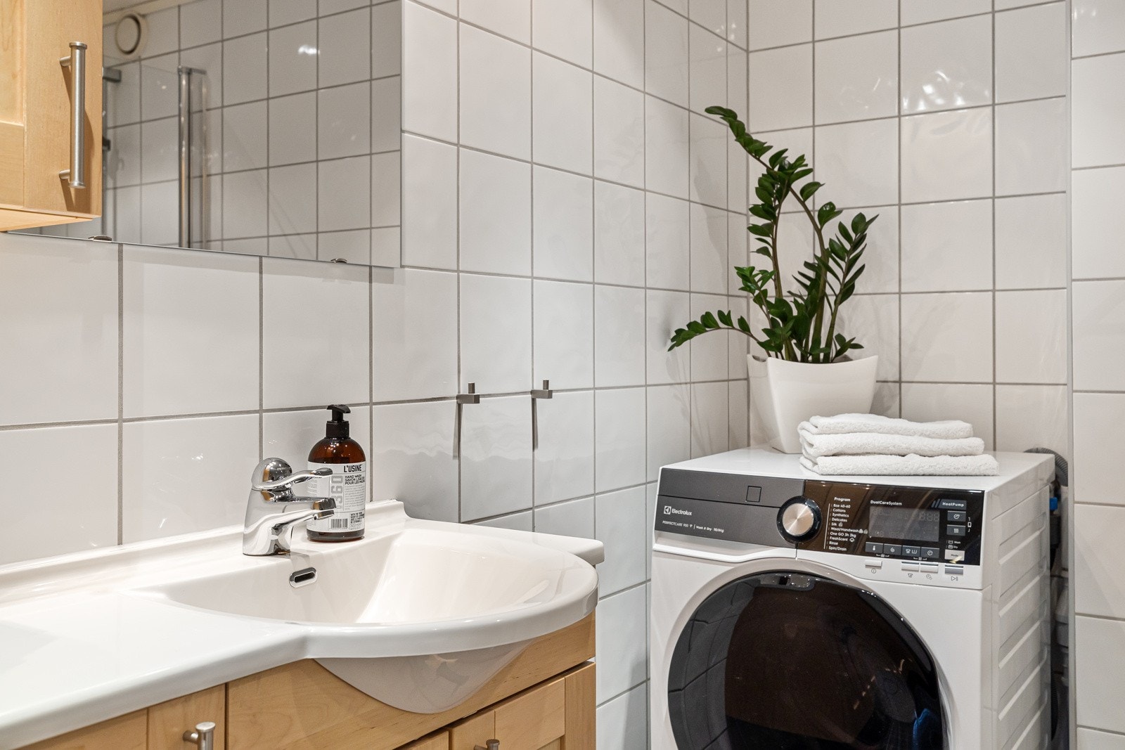 Badet er innredet med vegghengt innredning med ovenpåliggende servant og speil med overlys og stikkontakt. Galleribilde