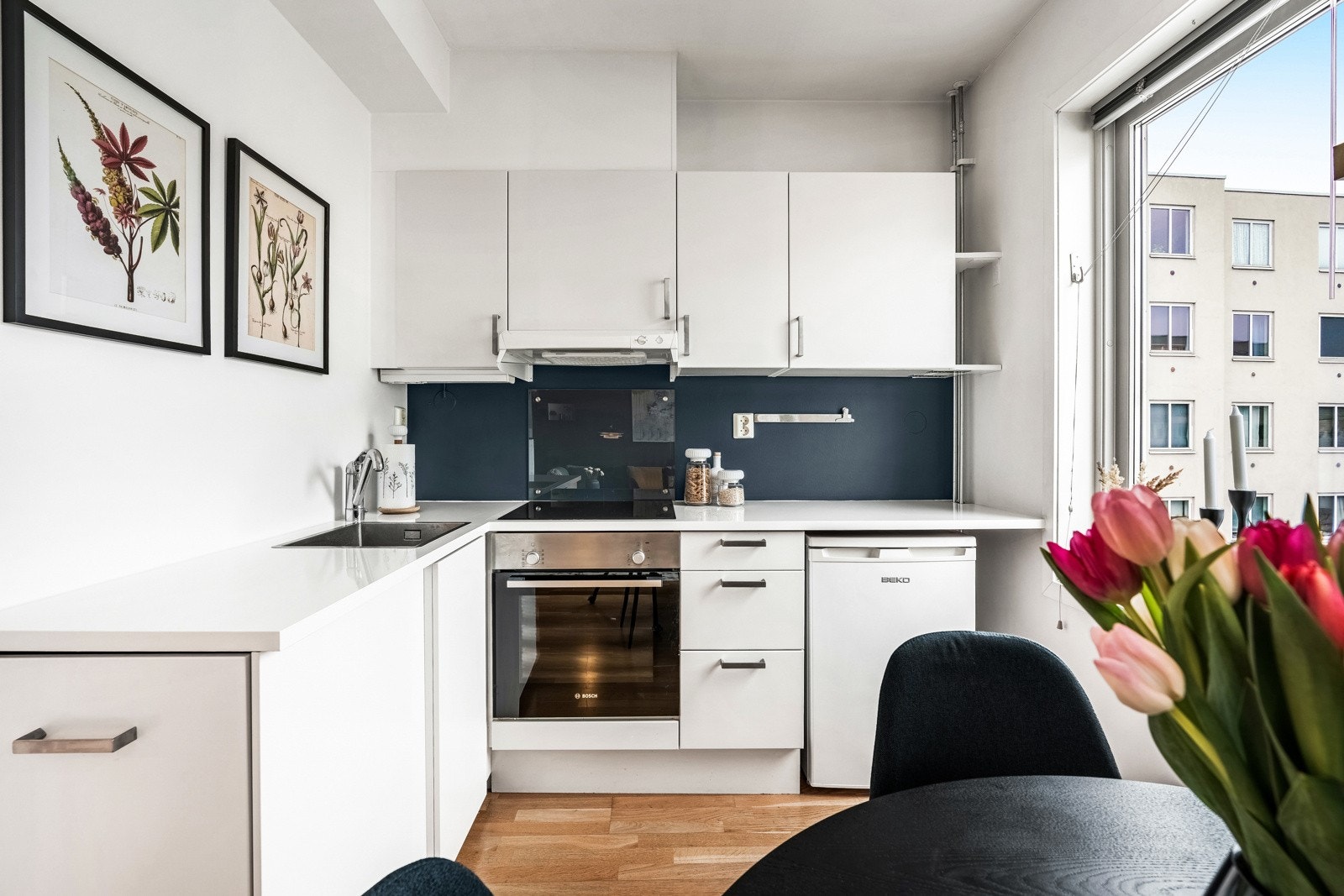 Kjøkkenet fra 2006 er utstyrt med hvit glatt kjøkkeninnredning, laminat benkeplate (2017), malt flate over benk, utslagsvask med ett-greps blandebatteri og kjøkkenventilator. Galleribilde