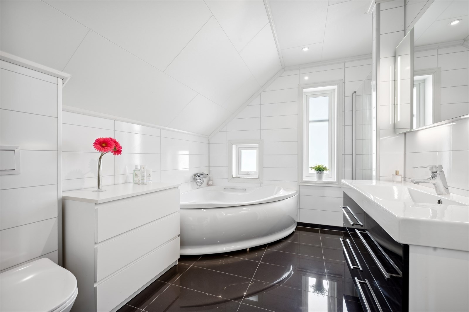 Badet i 2. etasje har sanitærutstyr bestående badekar, dusjnisje, heldekkende servant og veggmontert toalett. Galleribilde