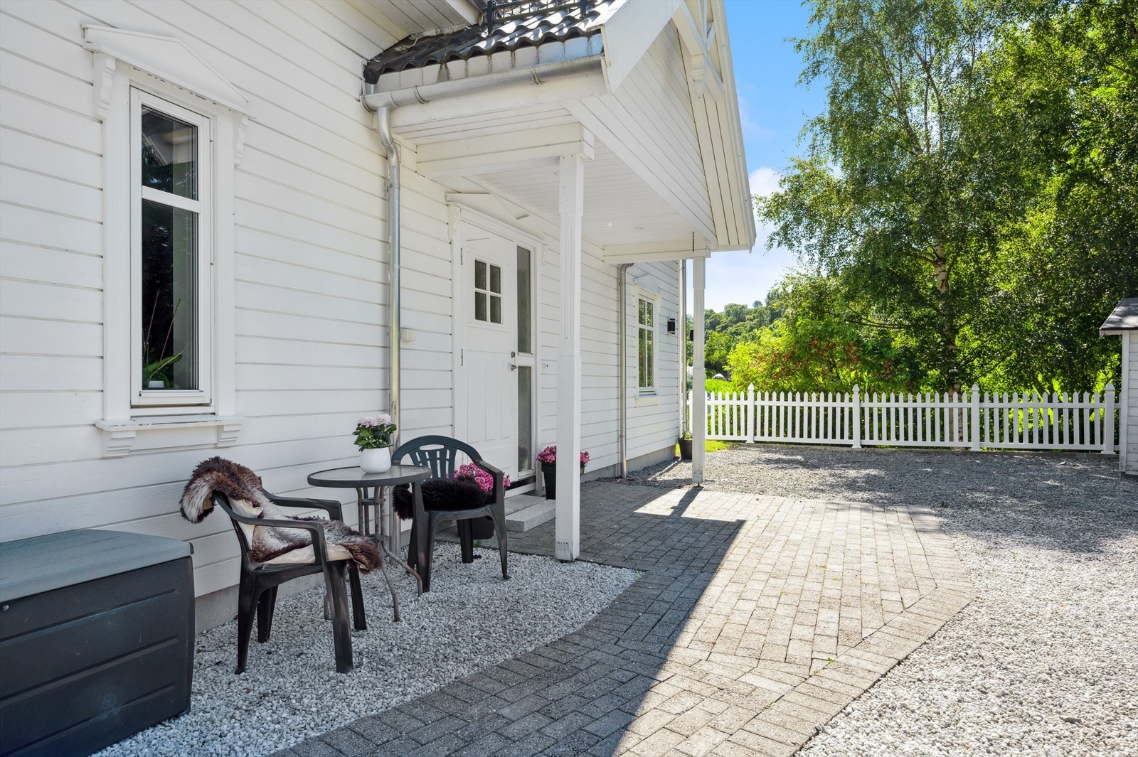 Koselig overbygget inngangsparti med steinbelagt platting. Galleribilde