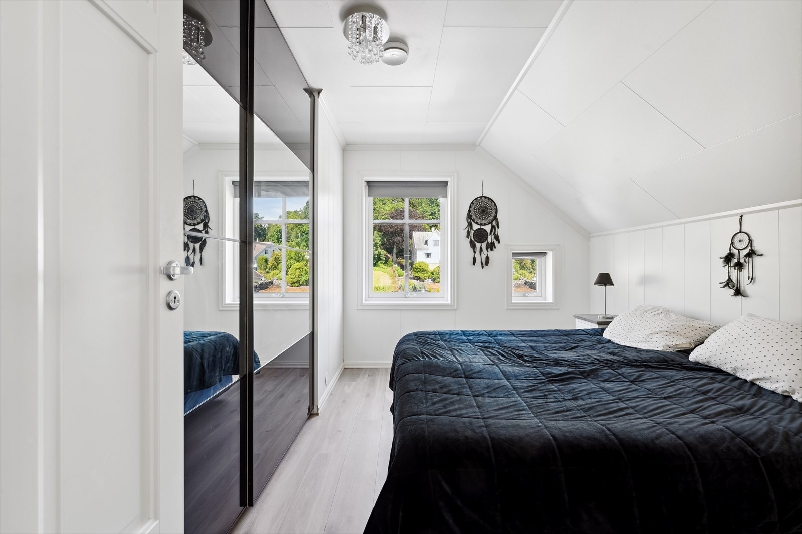 Videre er det stor skyvedørsgarderobe med frostet glass og speilfronter. Galleribilde