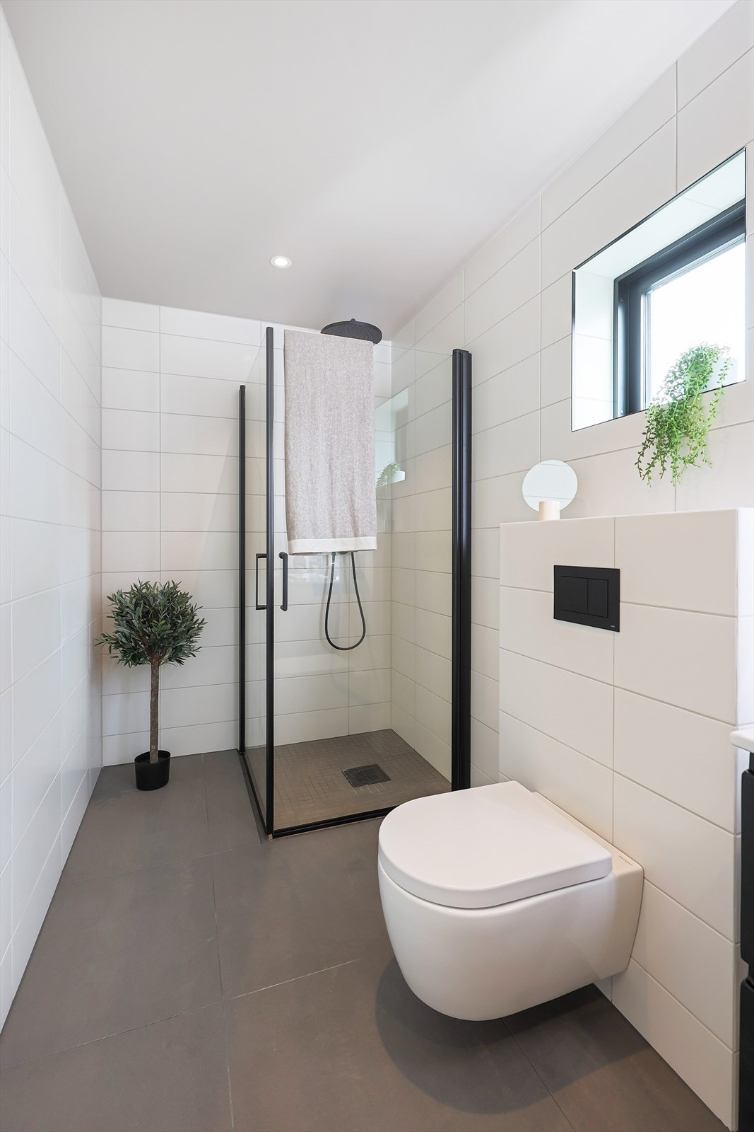 Badet er utstyrt med dusj, vegghengt wc og servant Galleribilde