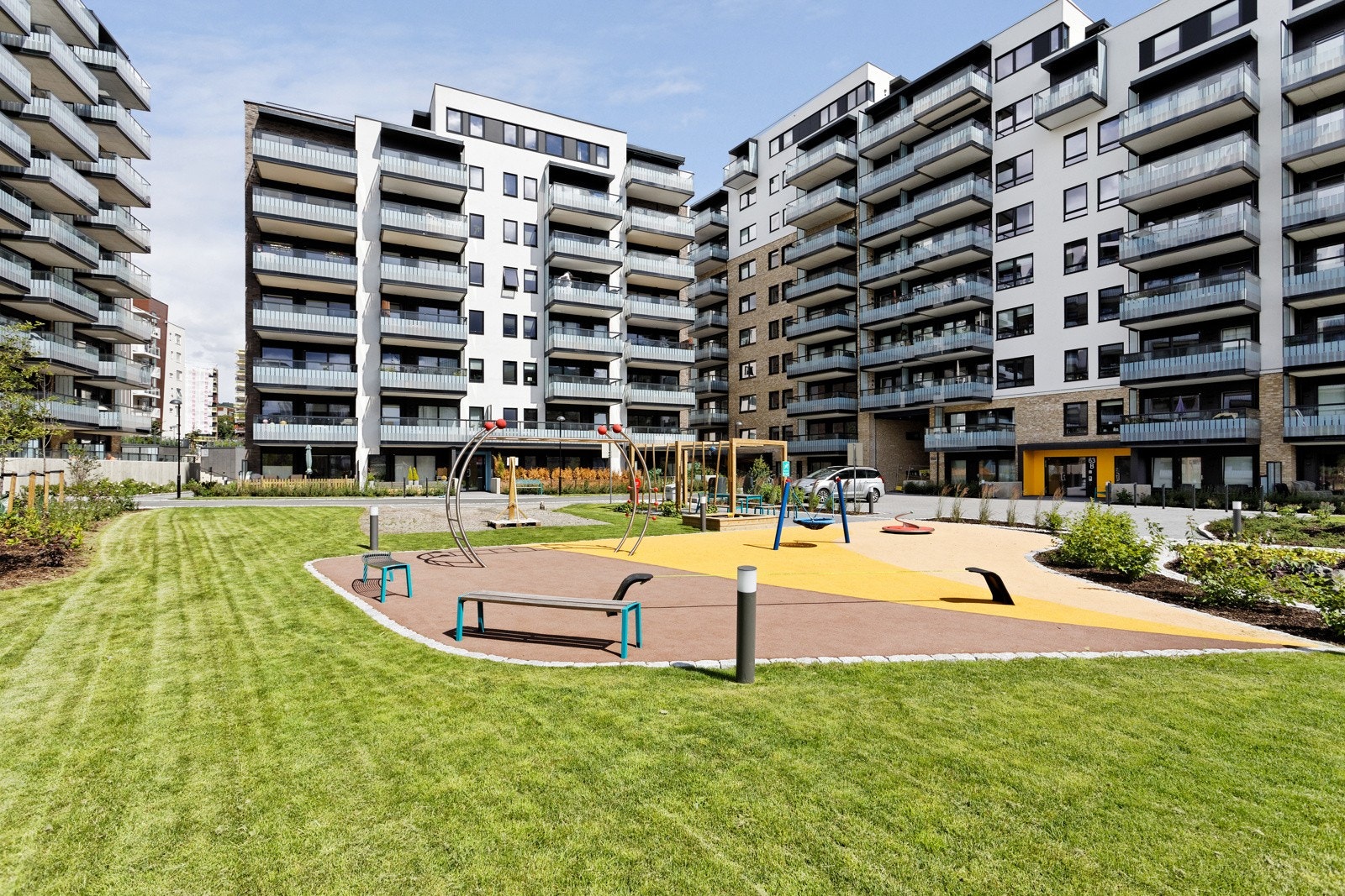 Fasade med pent opparbeidet fellesareal med sykkelparkering, sittegrupper og lekestativer, diverse busker og beplatninger. Her kan du bo godt i vakre og rolige, men likevel sentrale omgivelser. Galleribilde