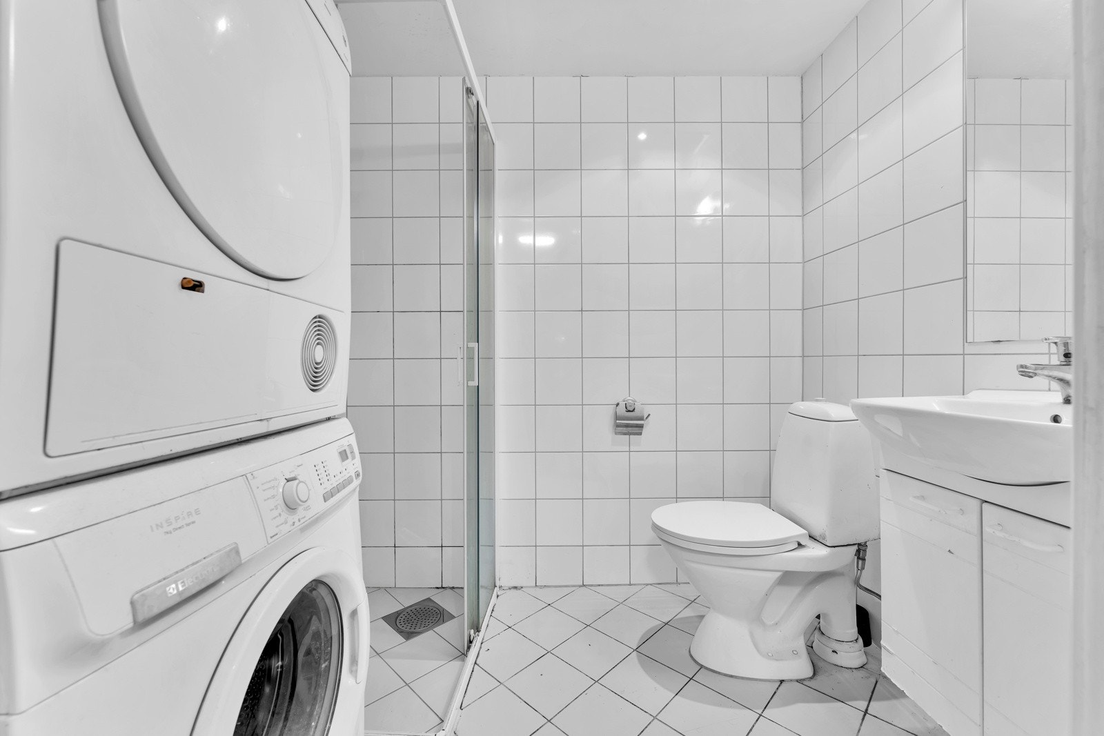 På badet er både gulv og vegger kledd i hvite fliser. Galleribilde