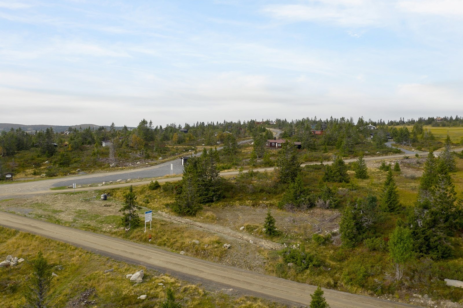 Bildet viser Birkebeinervegen som går på nedsiden av tomta og veien over mot Melsjøen på den andre siden av tomta. Galleribilde