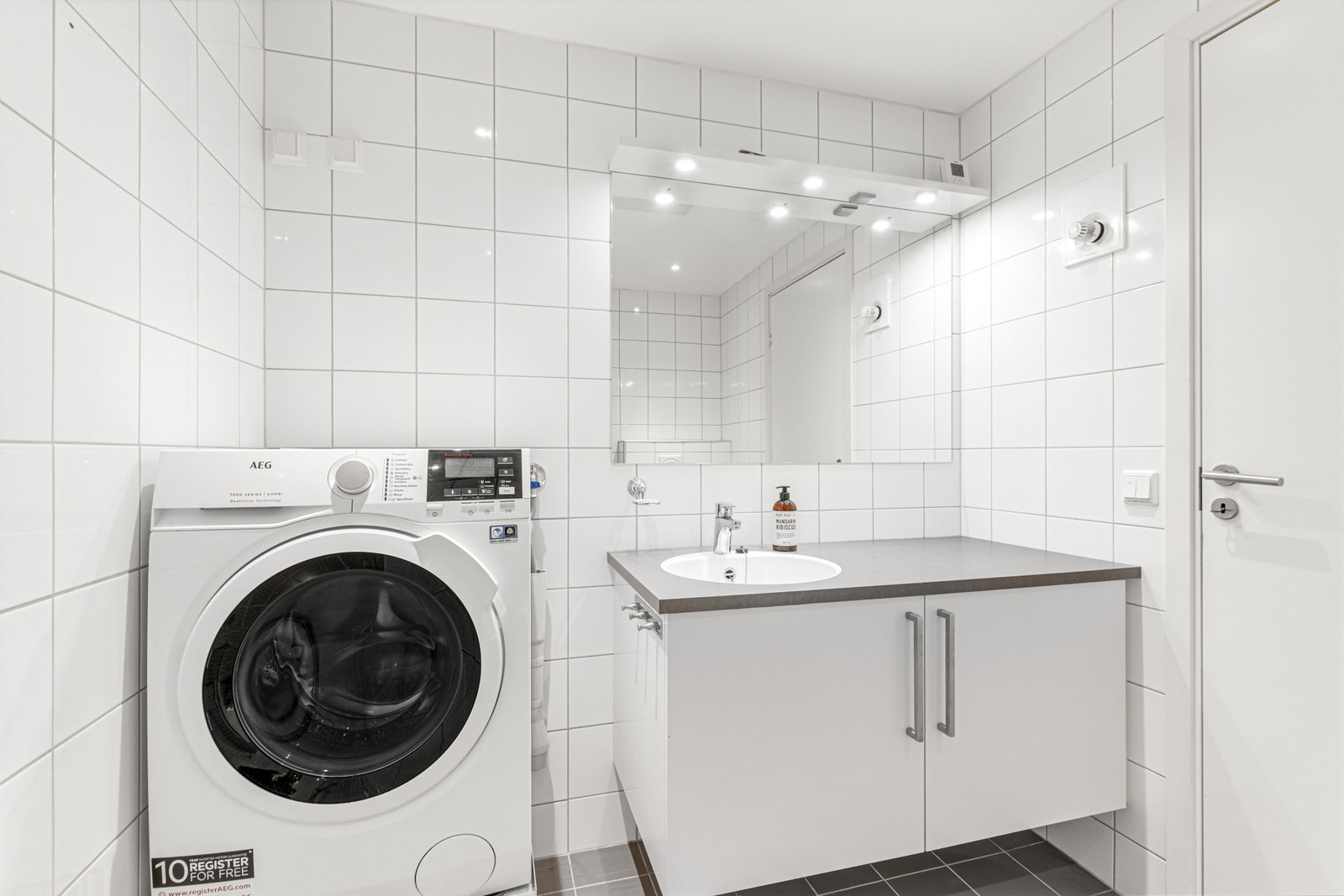 Moderne badromsinnredning og opplegg for vaskemaskin på badet. Galleribilde