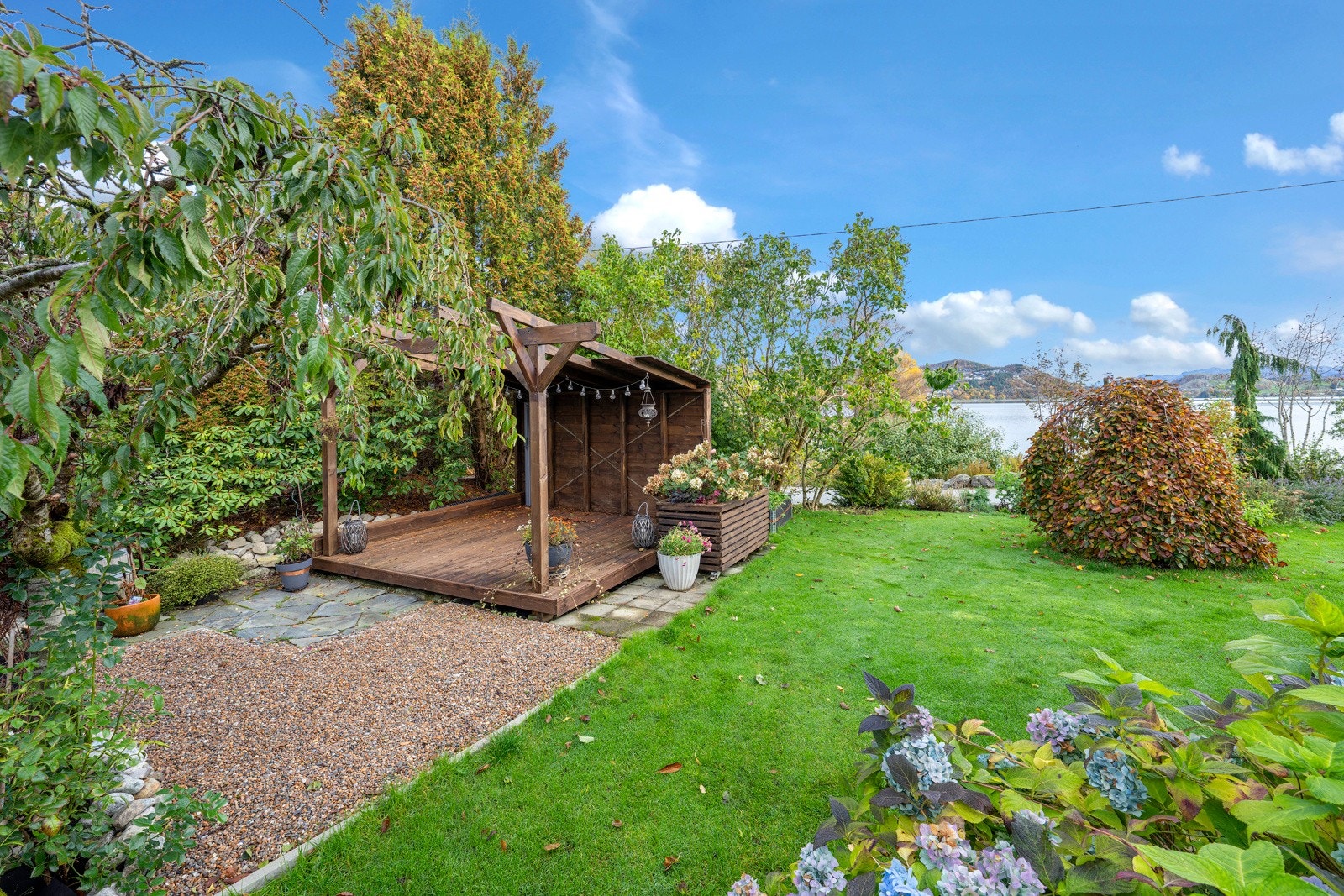 Flott pergola oppført i 2021, med nydelig utsikt over Edlandsvatnet i bakgrunnen. Galleribilde