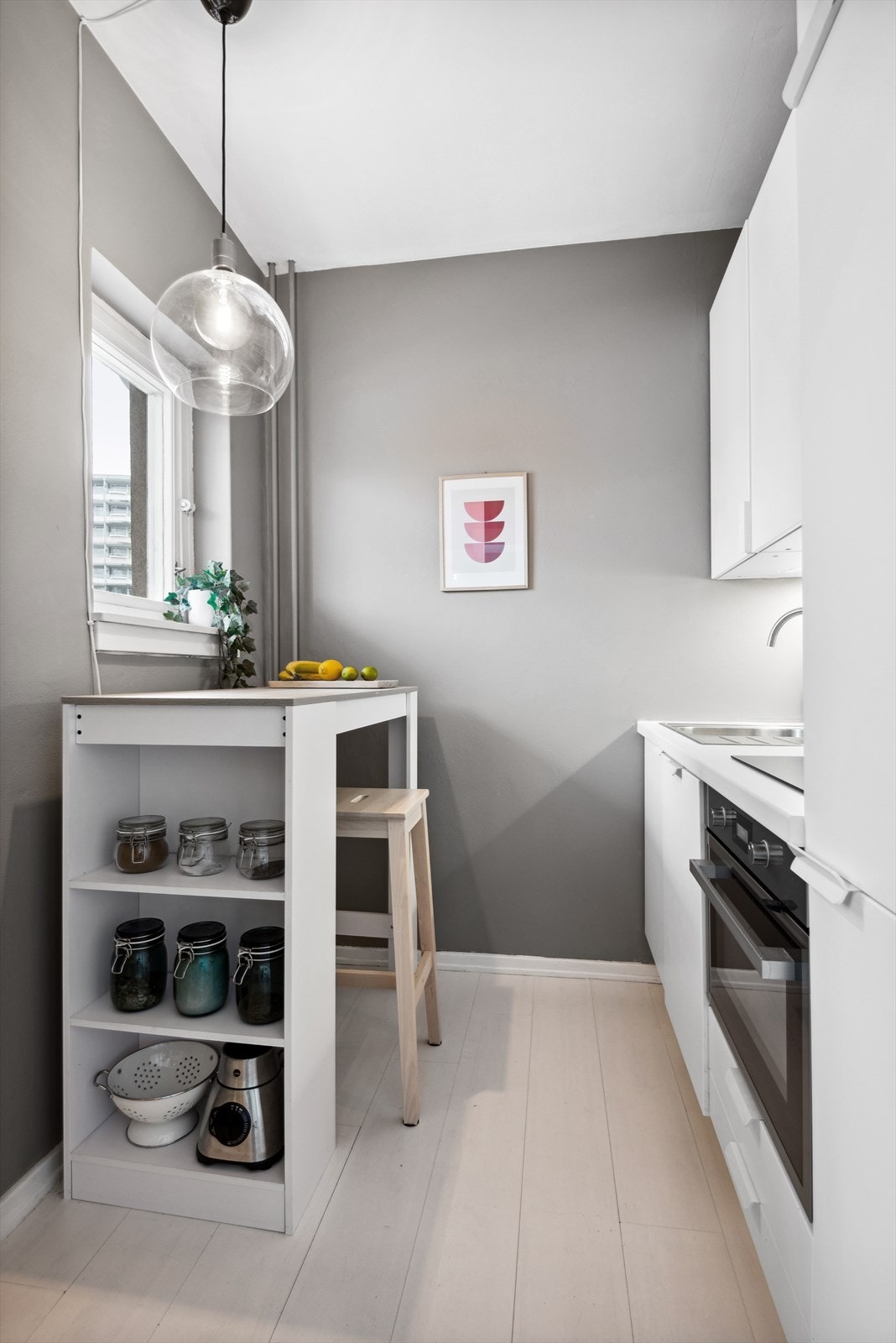 Det er satt opp en praktisk benkeløsning på kjøkkenet, noe som gir mer benkeplass og oppbevaring. Galleribilde