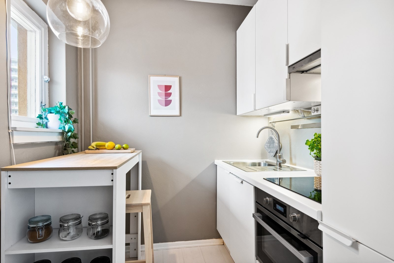 Tidsriktig og moderne kjøkken, bestående av laminert kjøkkeninnredning, lys under overskap, kullfiltervifte over integrert koketopp/ovn, integrert kjøl/frys og integrert oppvaskmaskin. Galleribilde