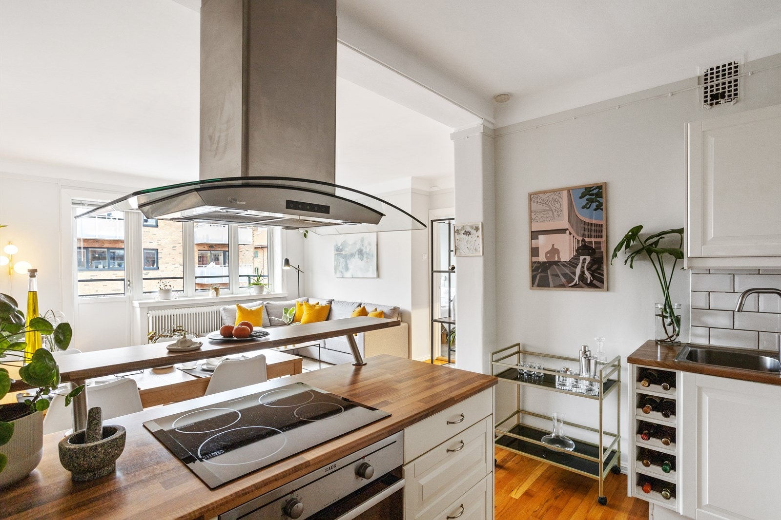 Kjøkkenet har laminat benkeplate med nedfelt kum i rustfritt stål, fliser på vegg over benk og ventilator med kullfilter over kokesone. Galleribilde