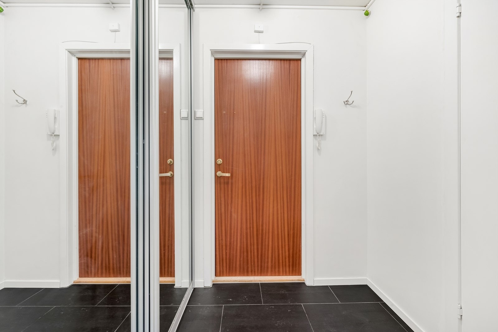 Entré med flislagt gulv.
God plass for å henge fra deg yttertøy og sette fra deg sko i skyvedørsgarderobe.
Med dørcallinganlegg slipper du gjestene enkelt inn fra bakkeplan. Galleribilde