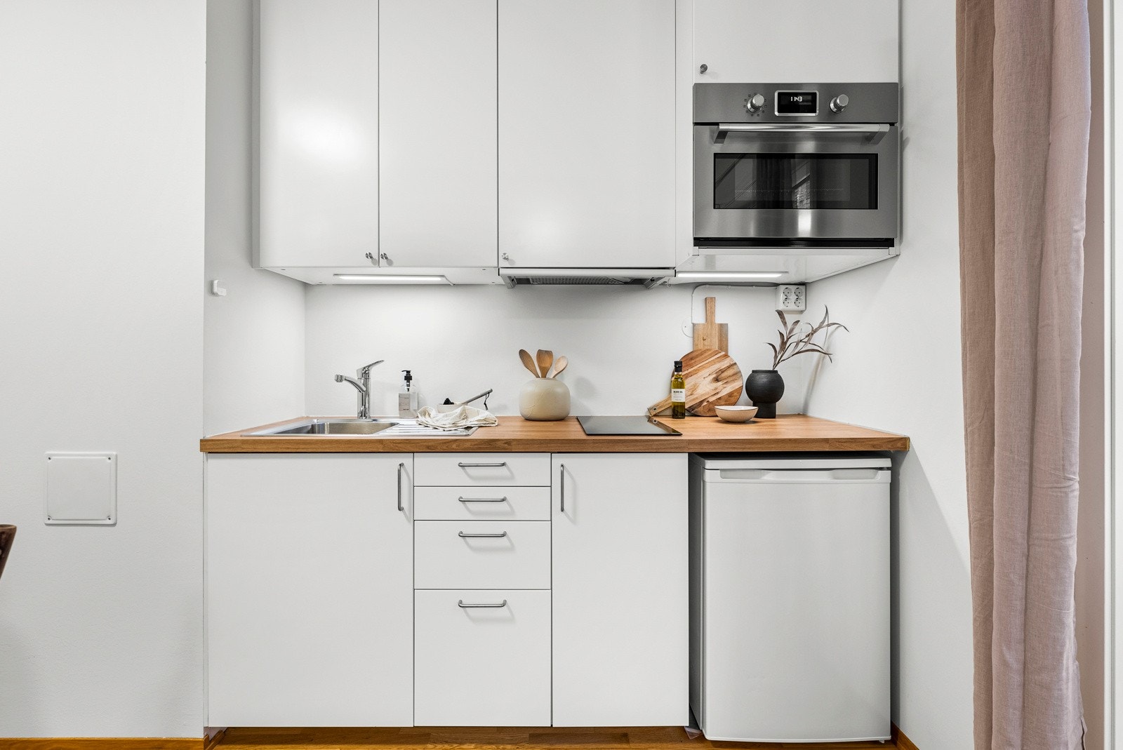 Kombiovn/mikrobølgeovn, ventilator med felles avtrekk, koketopp med to soner og kjøleskap. Galleribilde