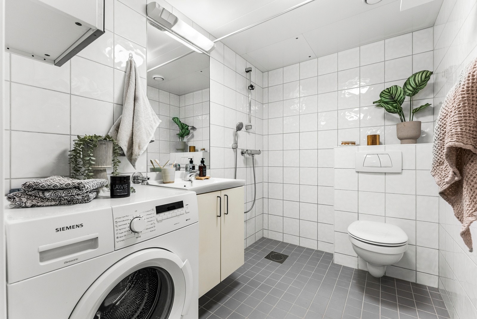 Romslig bad med med dusjhjørne, vegghengt toalett, varmekabler og opplegg for vaskemaskin/tørketrommel. Galleribilde