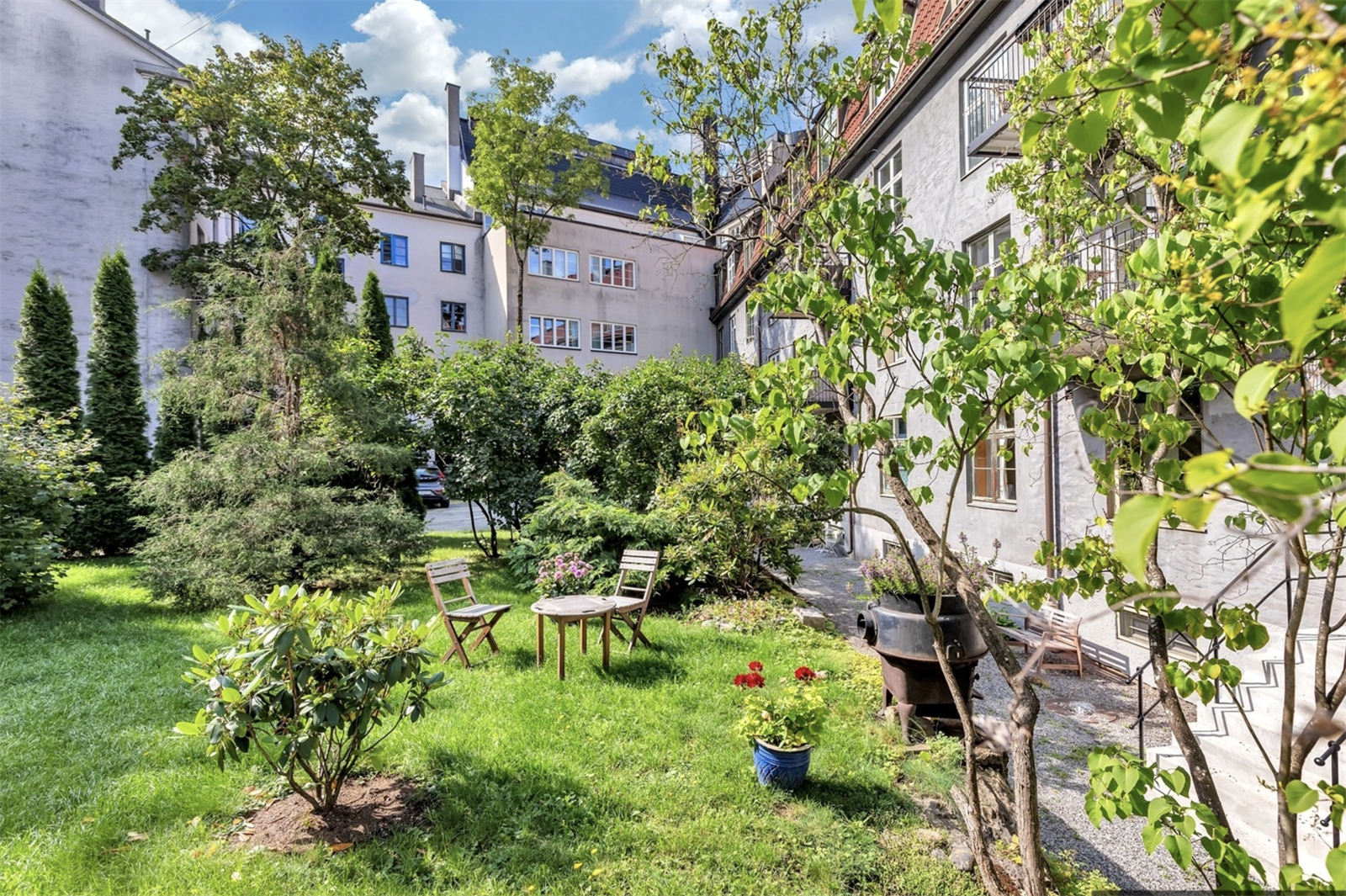 Balkongen vender inn mot en idyllisk bakgård (bilde fra sommerstid) Galleribilde