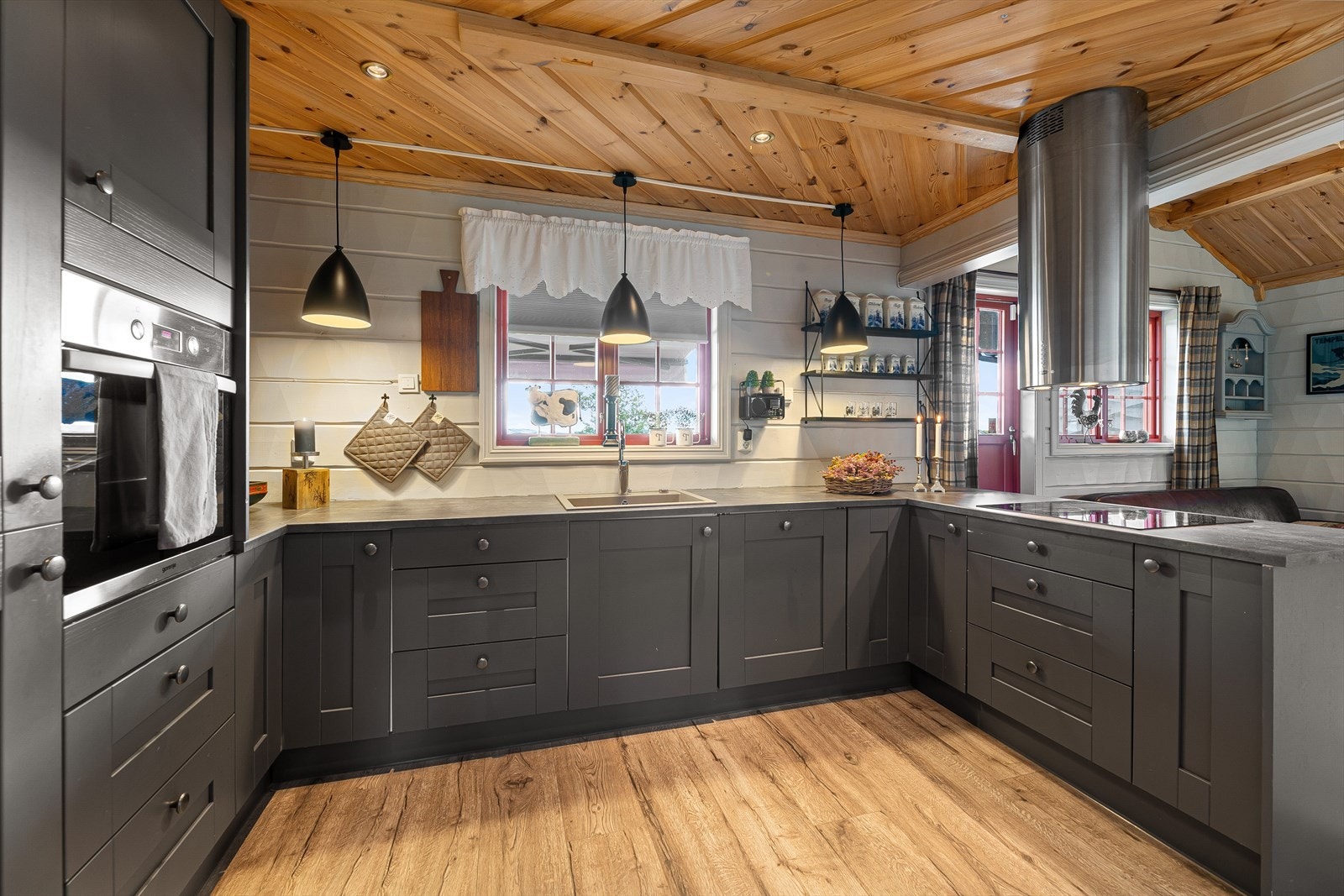 Hytta har et moderne og stilrent kjøkken med mørke, profilerte fronter. Galleribilde