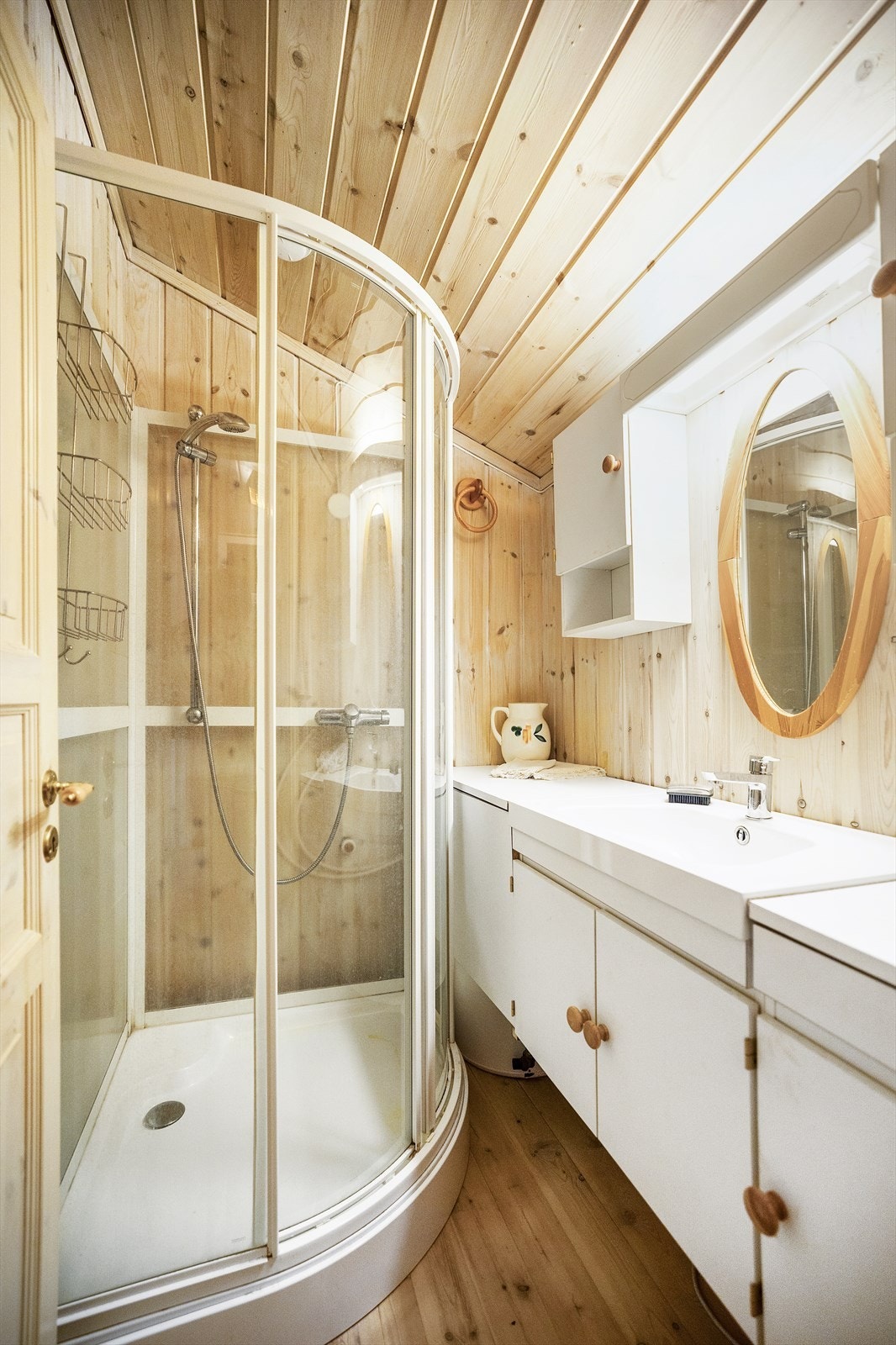 Rommet er utstyrt med dusjkabinett, servantskap og speil samt naturlig avtrekk. Furugulv og panel på vegg/tak. Galleribilde