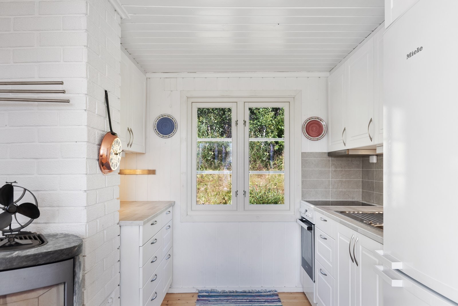 Kjøkkenet har godt med skapplass og god arbeidsplass på laminert benkeplate med kjøkkenkum. Laminatplater og belysning over benkeplate. Det er plass til frittstående komfyr og kjøleskap på kjøkkenet. Galleribilde