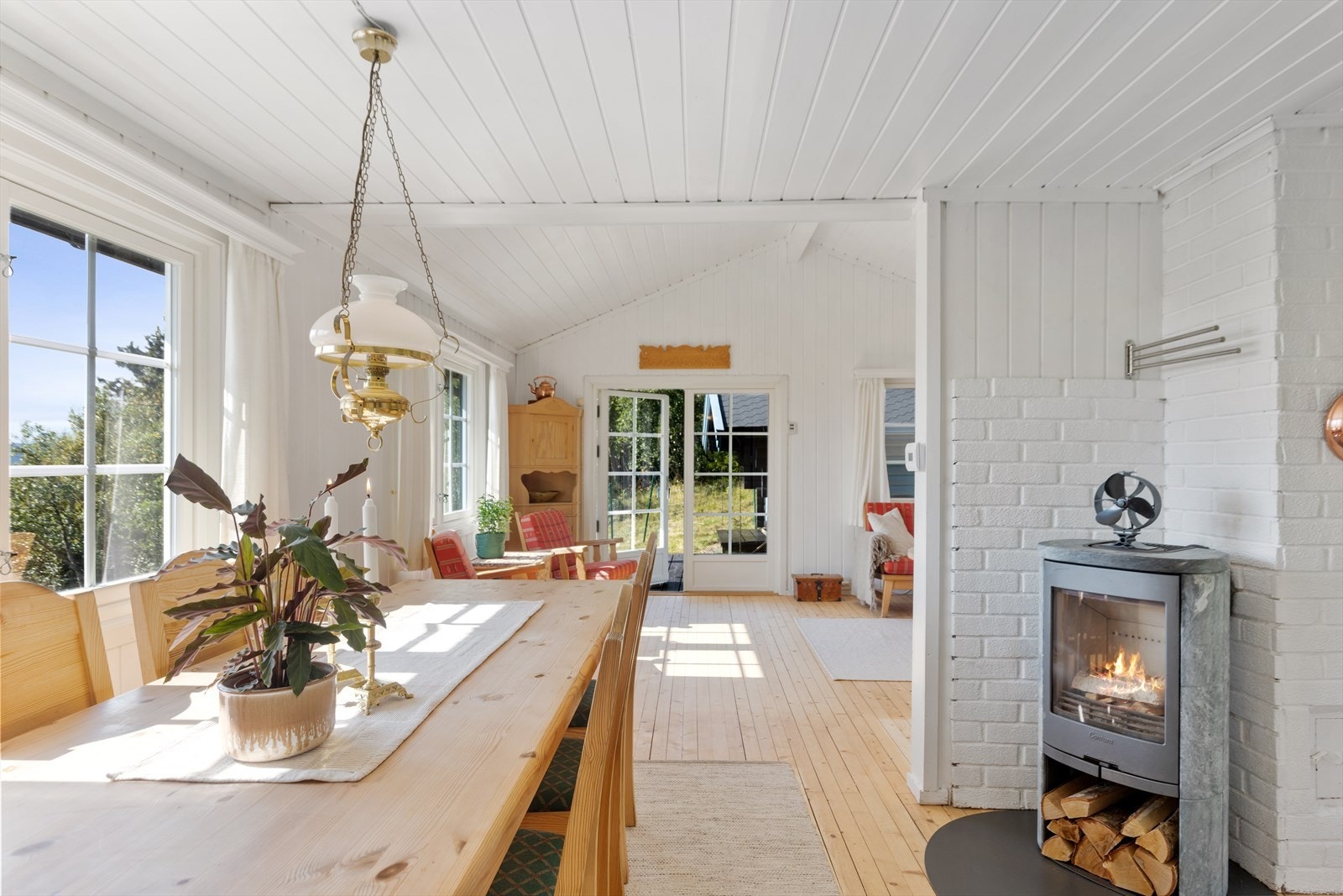 Stuen ligger i åpen til delvis løsning med kjøkkenet og spisestuen, og sammen danner de et lunt og innbydende allrom for hele familien Galleribilde