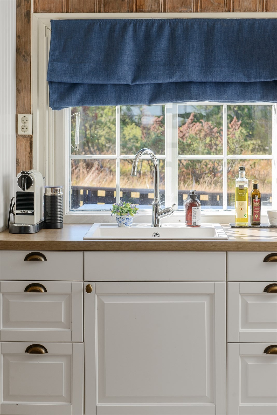 Vindu ut mot hyggelig og skjermet uteplass på baksiden av hytta. Galleribilde