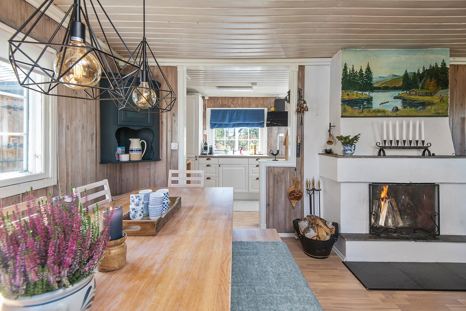 Fra spiseplassen og inn mot kjøkkenet. Peisen er fint plasser i rommet og kan nytes fra både spisebordet og sofakroken. Galleribilde
