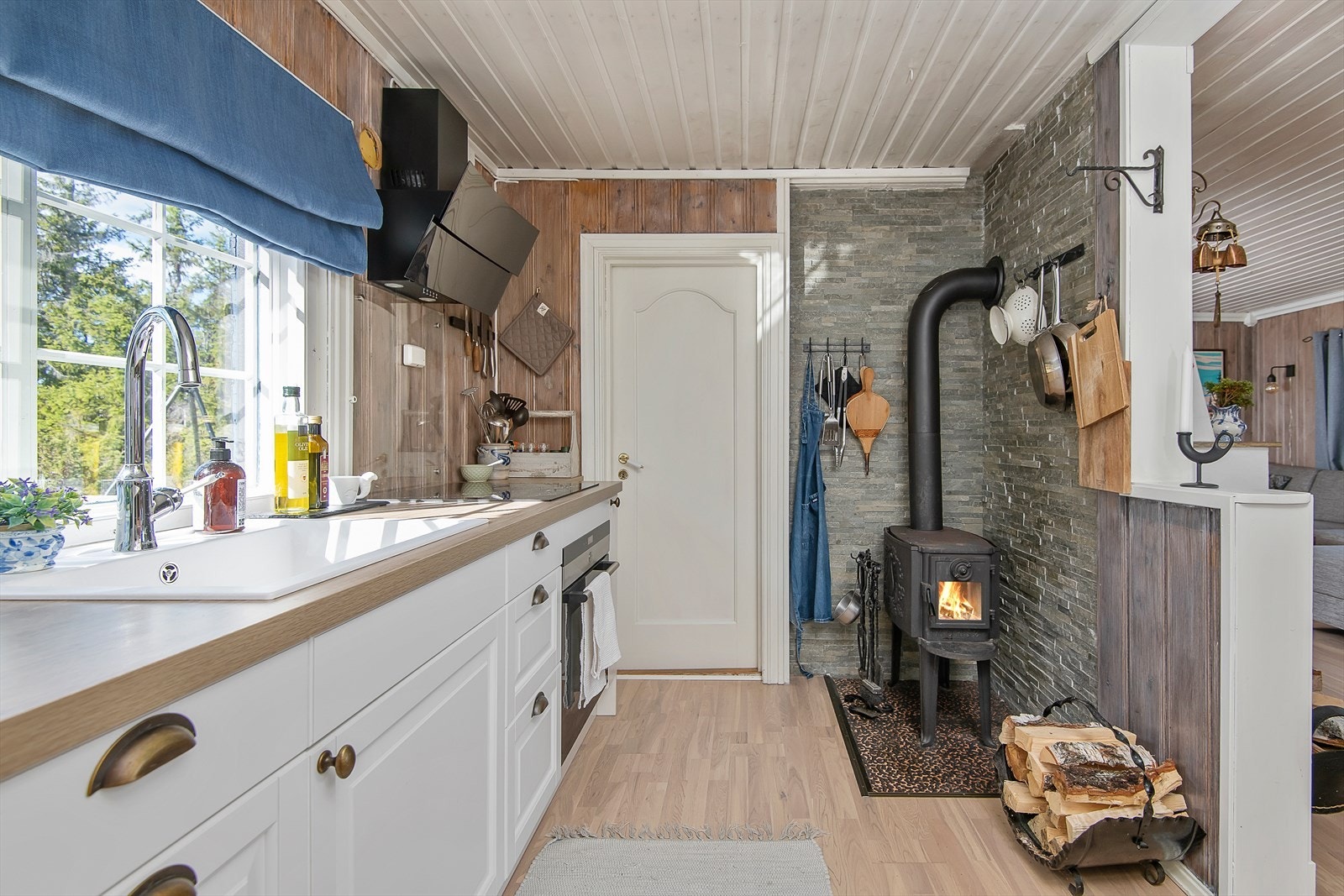 Kjøkkenet har innredning med hvite overflater. Godt med lys inn gjennom vinduet over benken. Galleribilde