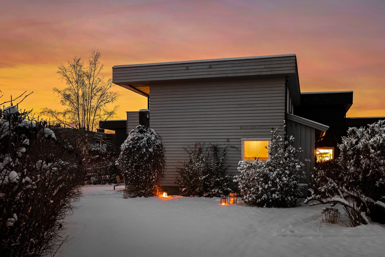 Stor, solrik hage som strekker seg rundt tre sider av boligen Galleribilde