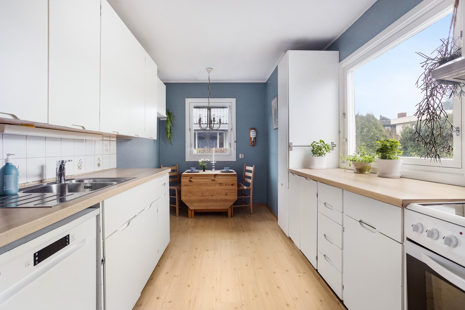 Seprat kjøkken med spiseplass og rikelig med skap- og benkplass Galleribilde