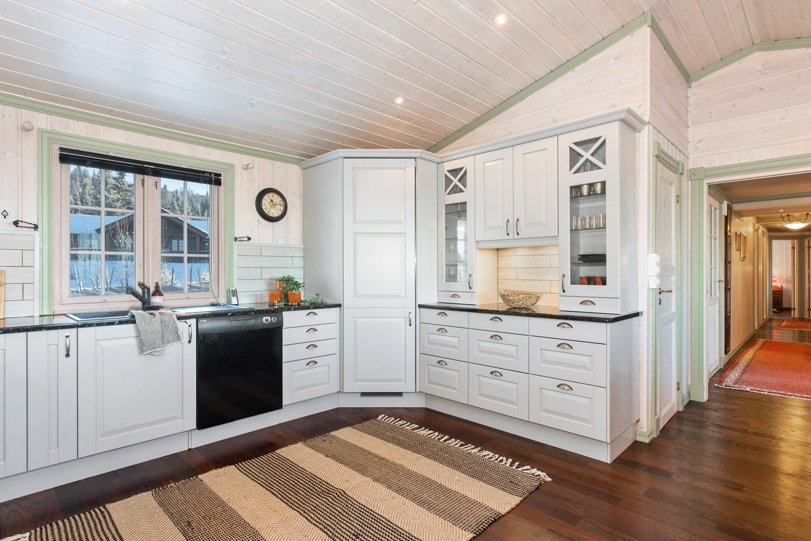 Lys kjøkkeninnredning og gode oppbevaringsmuligheter i over- og underskap. Galleribilde