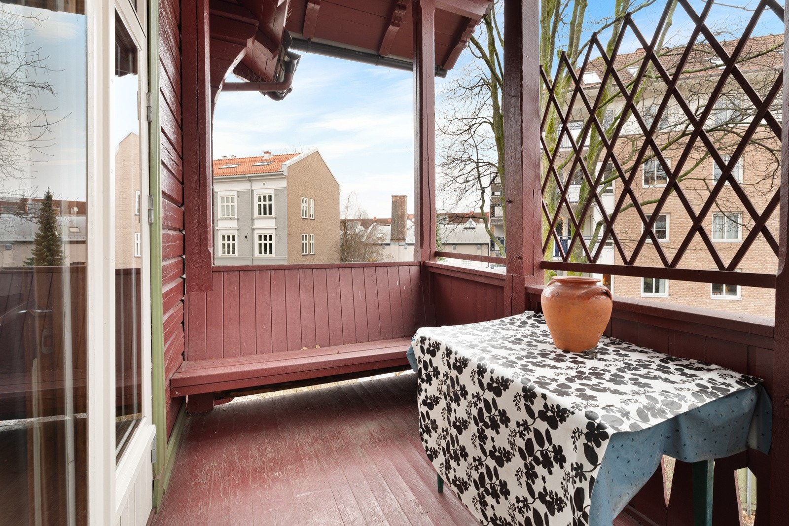 Balkongen har tett rekkverk som skjermer for innsyn og en koselig, plassbygget sittebenk Galleribilde