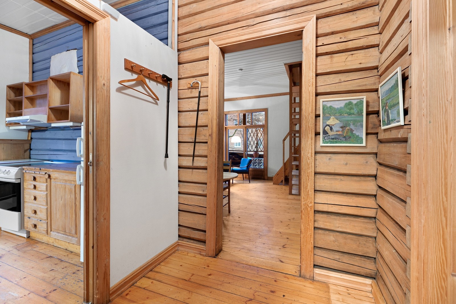 I gangen er det god takhøyde, originale tregulv og blottede tømmervegger Galleribilde