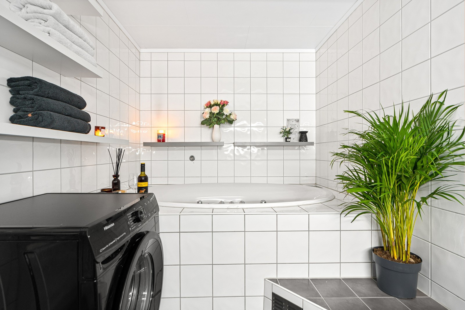 Bad/vaskerom med innebygd badekar, dusjnisje, toalett og servantskap. Opplegg for vaskemaskin.
