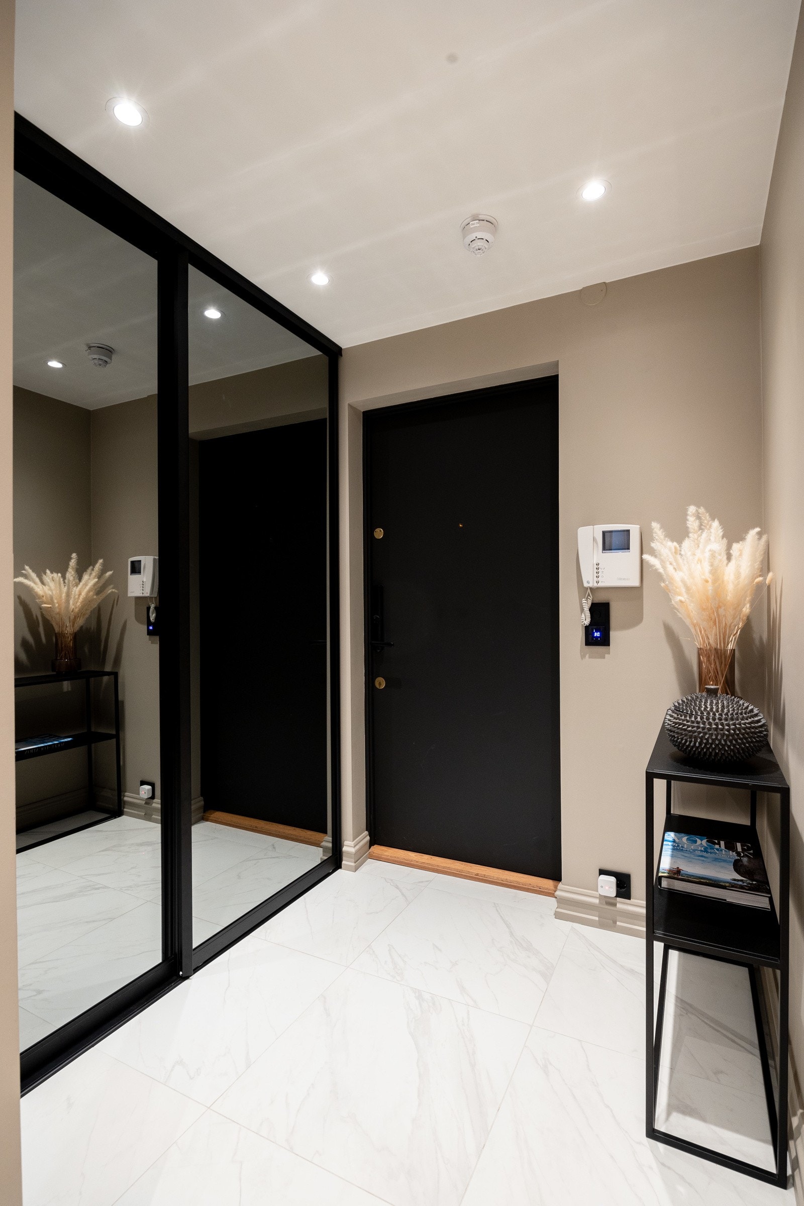 Man ankommer leiligheten i en innbydende entré med flislagt gulv, gulvvarme og en stor skyvedørsgarderobe. Galleribilde