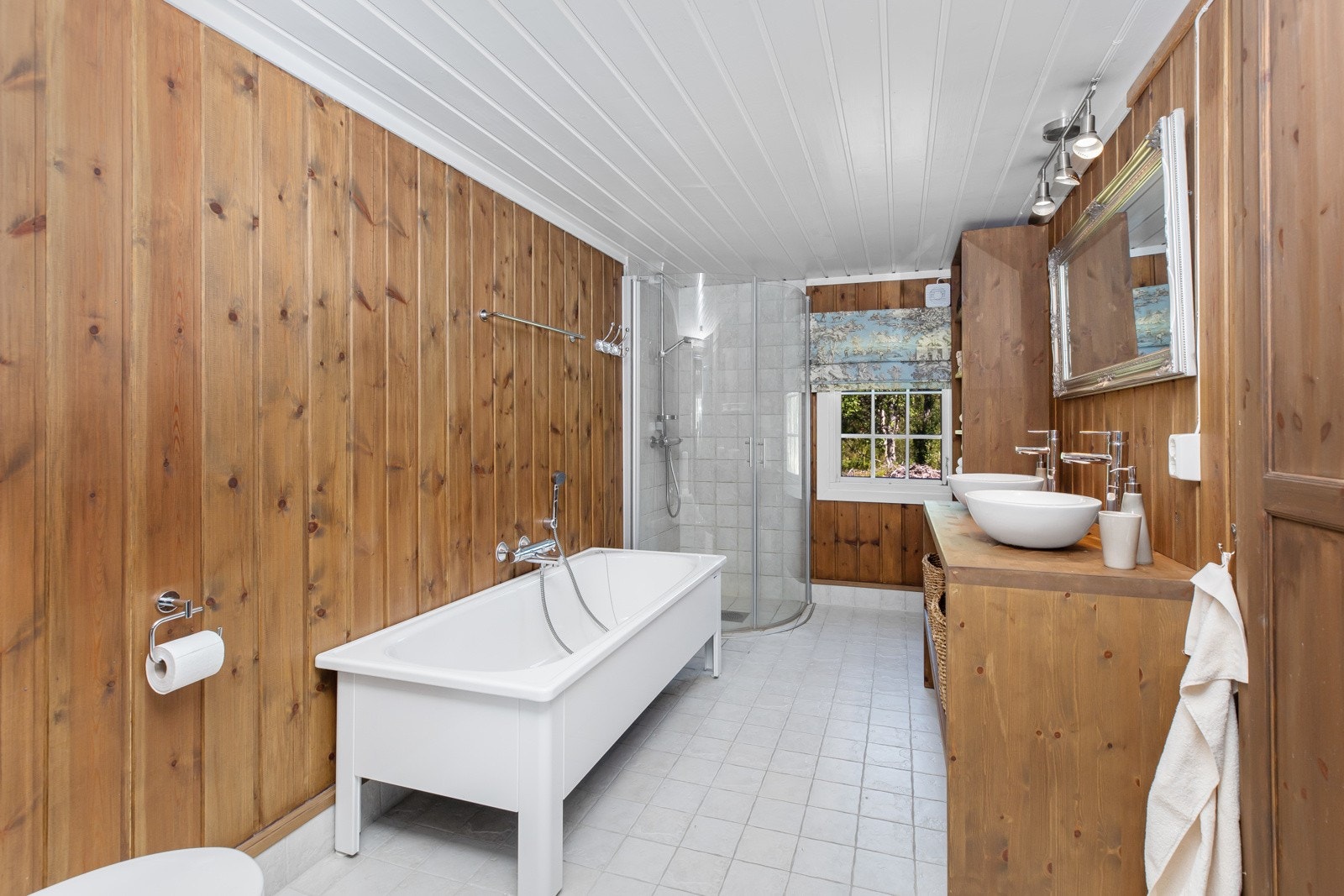 Plassbygde hyller på den ene siden. Det er dusj i hjørnet. Opplegg til vaskemaskin. Galleribilde