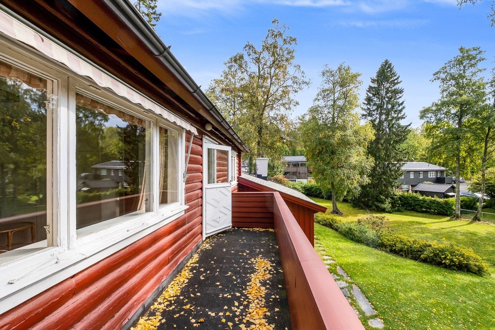 Romslig balkong i treverk med eldre platetekking. Galleribilde