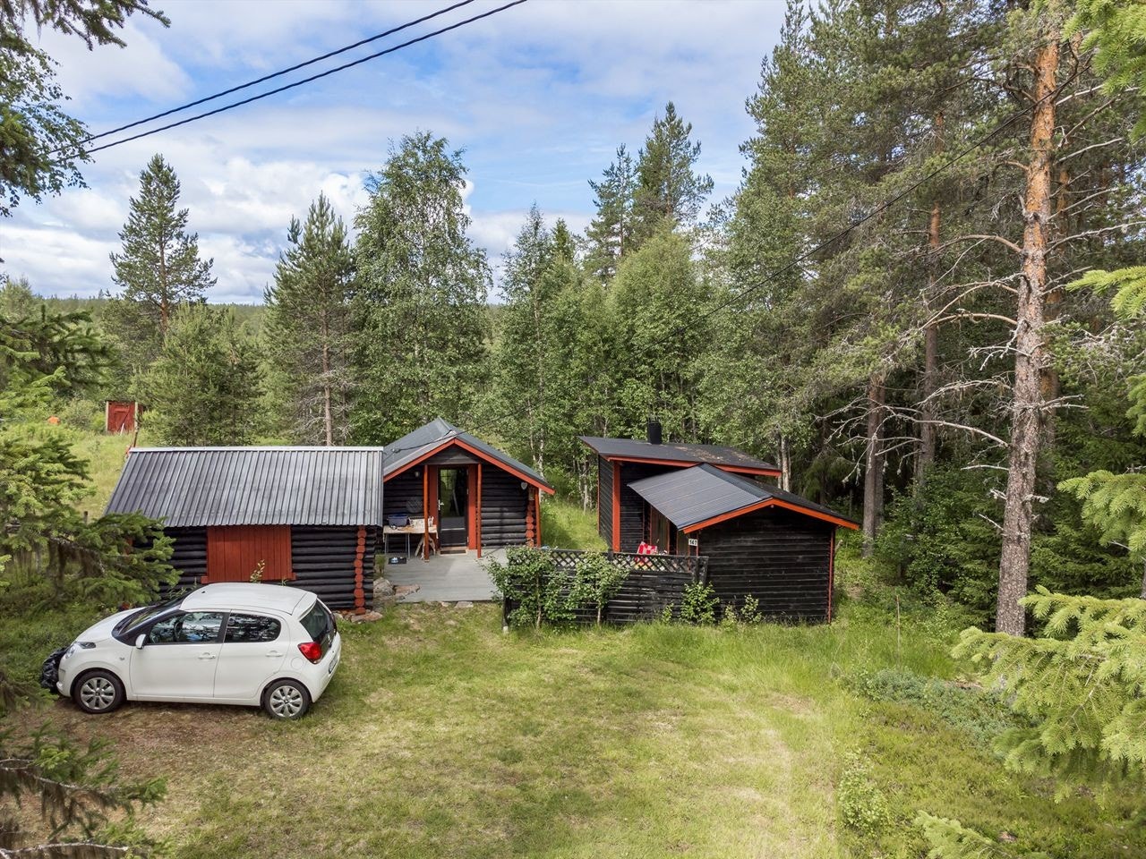 Parkeringsplass for flere biler foran hytta Galleribilde