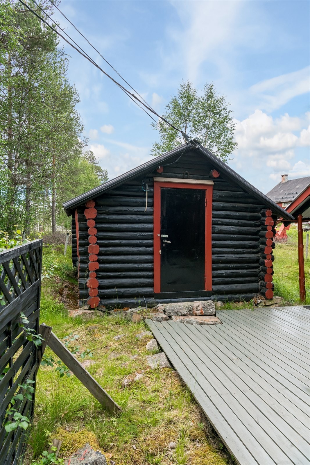 Alle hus er beiset svart med røde knuter og røde dør- og vindusomramninger Galleribilde