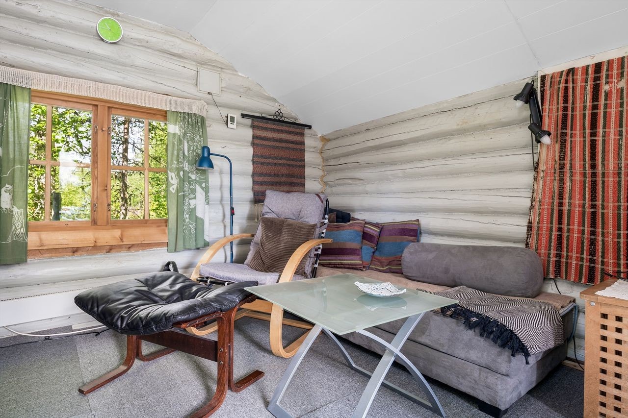 Stua er innredet med ekstra soveplass som også benyttes som sofa. Deilig lys fra vinduer og glassdør, og fine malte tømmervegger Galleribilde