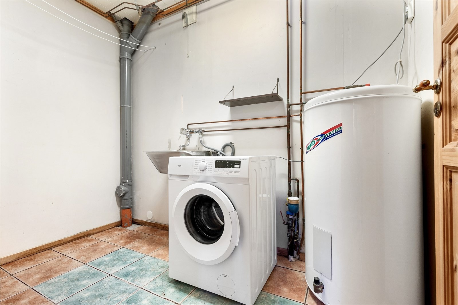 Romslig og praktisk vaskerom med potensiale for endring. Vaskerommet har flislagt gulv med varmekabler og opplegg for vaskemaskin og tørketrommel. I tillegg er det utslagsvask og plass for varmtvannsbereder Galleribilde