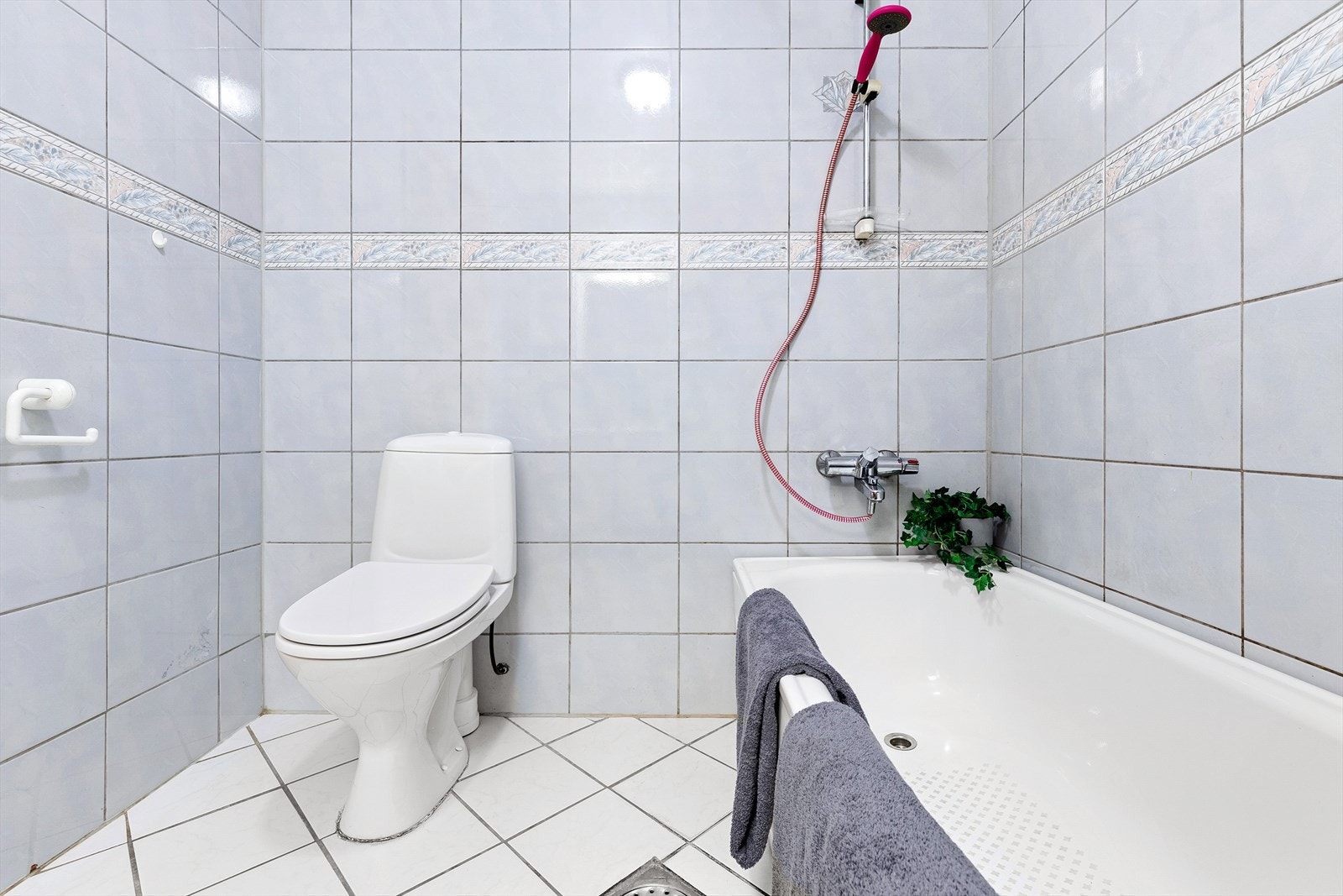 Flislagt bad med varmekabler i gulv. Innredning er bestående av bl.a klosett og badekar Galleribilde