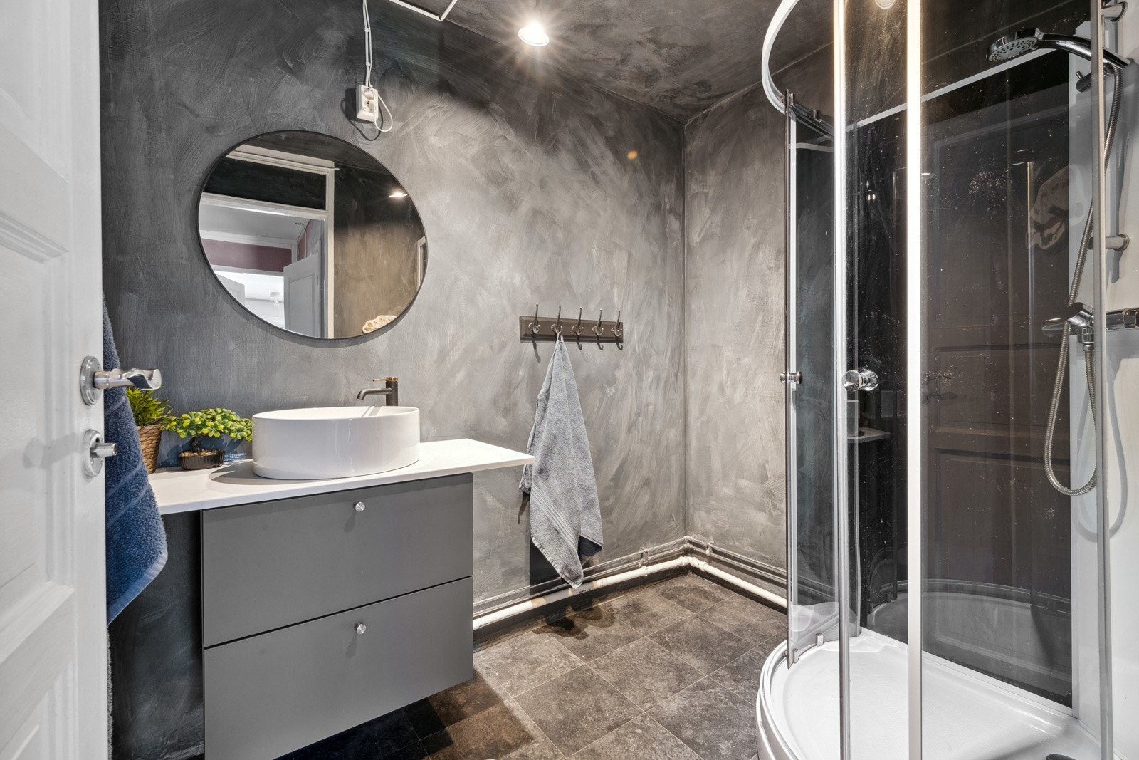 Badet har dusjkabinett og innredning med toppmontert skålservant. Galleribilde