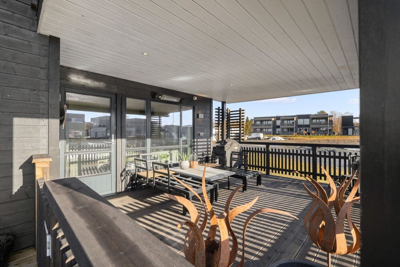 Stor takoverbygget terrasse med god plass til utemøbler. Spotbelysning i himling. Galleribilde